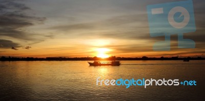 Boat Cruising At Sunset Stock Photo