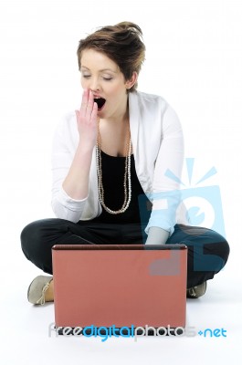 Bored lady yawning with laptop Stock Photo