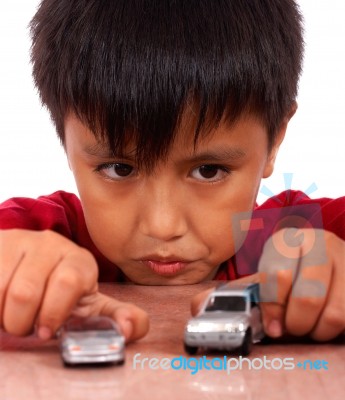 Boy Playing With Toy Cars On A Table Stock Photo