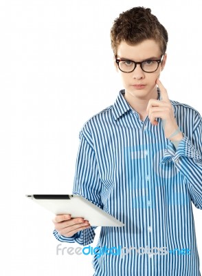 Boy Thinking By Holding Tablet Pc Stock Photo