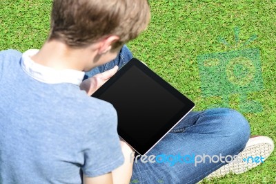 Boy With Crossed Legs Relaxing Outdoors Stock Photo