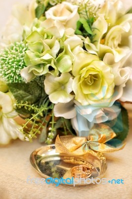 Bridal Bouquet And Wedding Rings On The Table Stock Photo