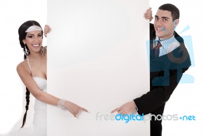 Bride And Groom Pointing At Blank Board Stock Photo