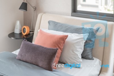 Brown Pillows On Modern Bed In Bedroom Stock Photo