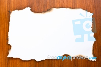 Burned Paper On Wooden Backdrop Stock Photo