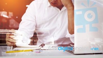 Business Man Seated At Home Office Space Looking At Report Stock Photo