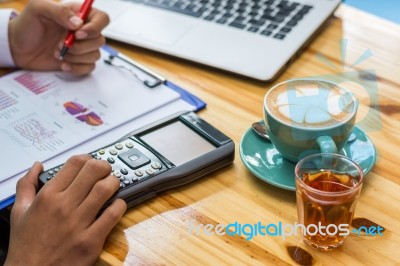 Business Man Sitting On A Calculator To Figure Out In A Coffee S… Stock Photo