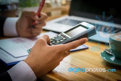 Business Man Sitting On A Calculator To Figure Out In A Coffee S… Stock Photo