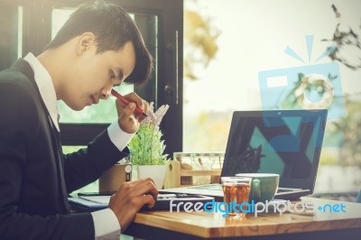 Business Man Sitting On A Calculator To Figure Out In A Coffee S… Stock Photo