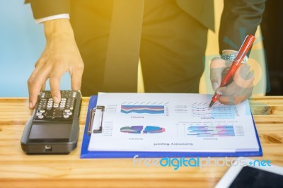 Business Man Sitting On A Calculator To Figure Out In A Coffee S… Stock Photo