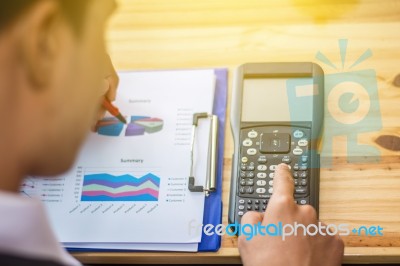 Business Man Sitting On A Calculator To Figure Out In A Coffee S… Stock Photo