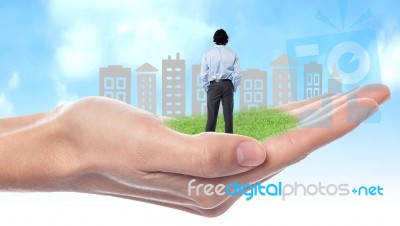 Business Man Standing On Palm Stock Photo