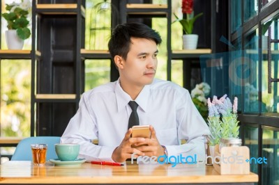 Business Man Using Mobile Phone While Sitting In The Coffee Shop… Stock Photo