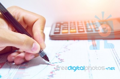 Businessman Hand Holding A Pen Working On Document Stock Photo
