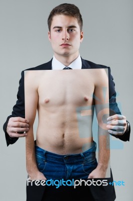 Businessman In Black Suit Holding A Photo Of A Naked Male Torso Stock Photo