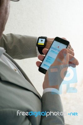 Businessman Ordering A Taxi Using His Apple Watch Stock Photo