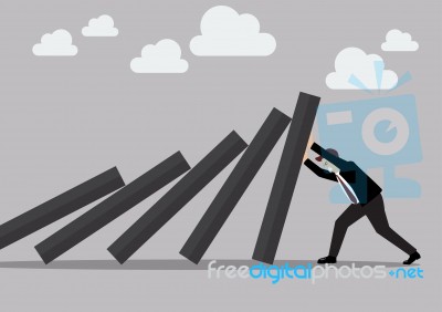 Businessman Pushing Hard Against Falling Deck Of Domino Tiles Stock Image