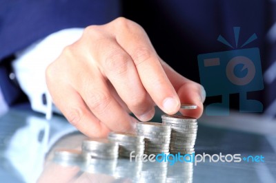 Businessman Stacking Coins Stock Photo