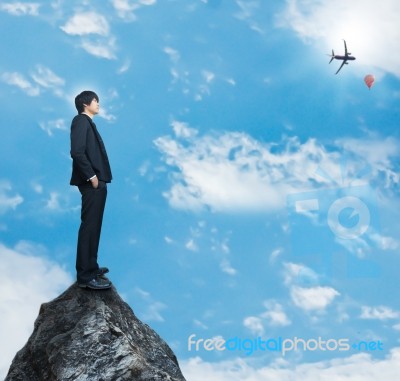 Businessman Standing On Rock Stock Photo