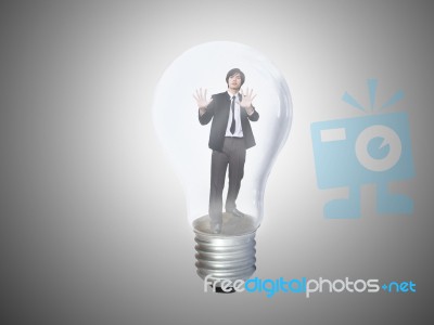 Businessman Trapped In Lightbulb Stock Photo