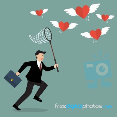 Businessman Trying To Catch Hearts Flying Stock Image