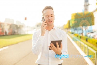 Businessman With Mobile Phone Tablet In Hands Stock Photo