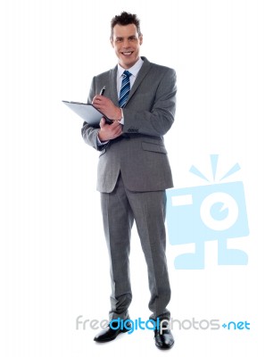 Businessman Writing On Clipboard Stock Photo