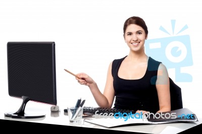 Businesswoman Holding Pen And Pointing Monitor Stock Photo