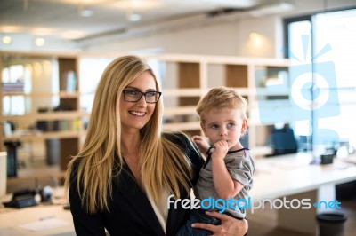Businesswoman With Small Child In The Office Stock Photo
