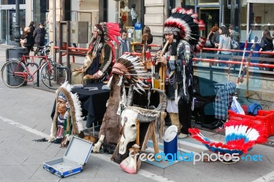 Buskers Dressed As American Red Indians Making Music In Milan Stock Photo