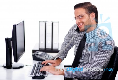 Busy Professional Using Telephone While At Work Stock Photo