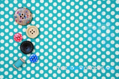 Buttons On Blue Polka Dot Fabric Background Stock Photo