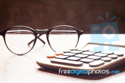 Calculator With Eyeglasses On Wooden Table Stock Photo