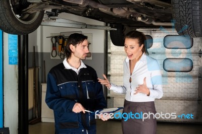 Car Mechanic With Angry Female Customer Stock Photo
