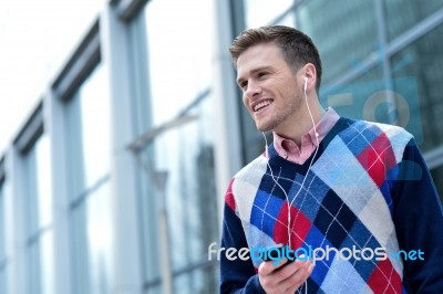 Casual Man Hearing Music Outside Modern Building Stock Photo