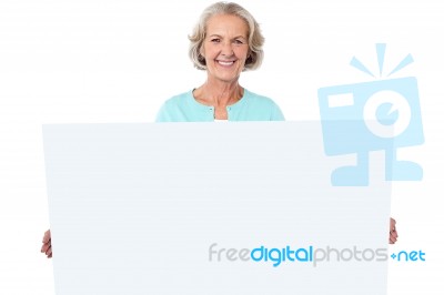 Casual Old Lady Holding A Blank Billboard Stock Photo