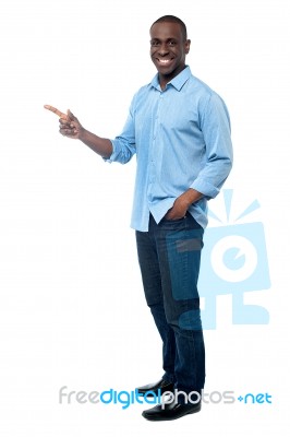 Casual Young Man Pointing Away Stock Photo