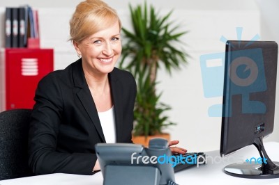 Cheerful Aged Woman Working At The Desk Stock Photo