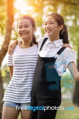 Cheerful Asian Teenager Relaxing With Happiness Emotion In Green Park Stock Photo