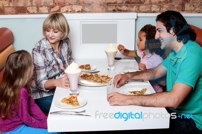 Cheerful Family Of Four Enjoying Breakfast Stock Photo