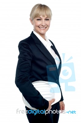 Cheerful Female Architect Holding Hardhat Stock Photo