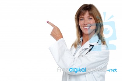 Cheerful Female Doctor Pointing Away Stock Photo