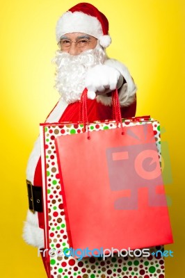 Cheerful Santa Holding Vibrant Colored Shopping Bags Stock Photo