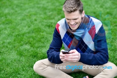 Cheerful Young Relaxed Guy Using Mobile Phone Stock Photo