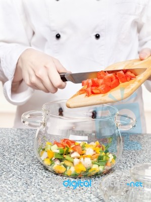 Chef Adds Tomatoes In A Glass Bowl Stock Photo