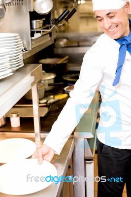 Chef Arranging Clean Utensils Stock Photo