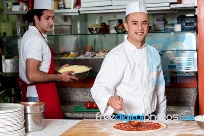 Chef Baker Making Pizza At Kitchen Stock Photo