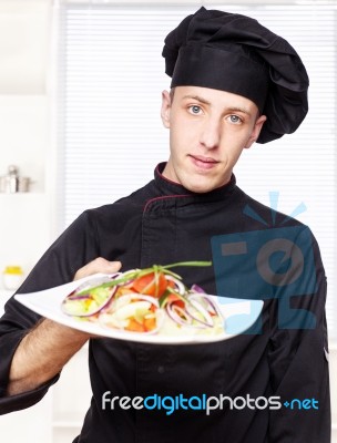 Chef In Black Uniform Offer Salad Stock Photo