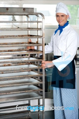 Chef Moving Tray Rack Towards Corner Stock Photo