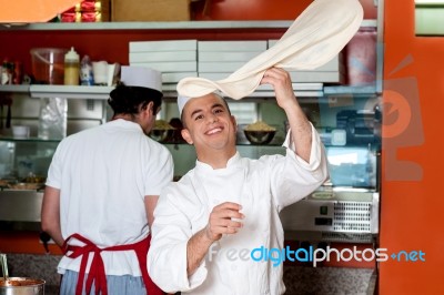 Chef Throwing Up Thin Base Dough Stock Photo